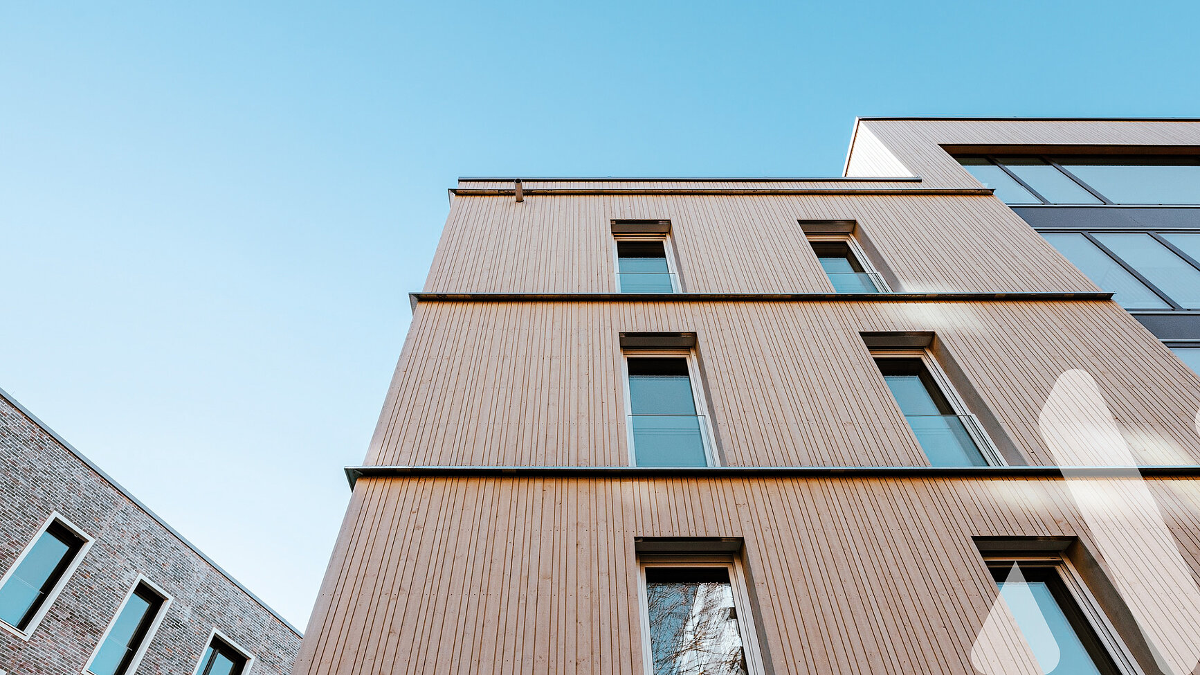 Außenansicht von Wohngebäuden mit Holz- und Klinkerfassaden in Ulm
