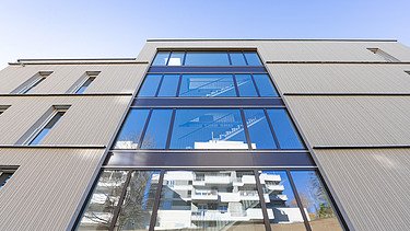 Außenansicht Gebäude Safranberg mit Holzfassade Außenansicht Gebäude Safranberg mit attraktiver vorvergrauter Holzfassade