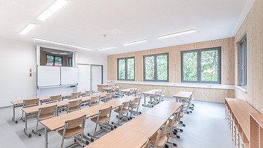 Klassenzimmer mit Betondecke und sichtbarer Holzoberfläche der Innenwände Klassenzimmer mit Betondecke und sichtbarer Holzoberfläche der Innenwände