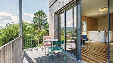 Außenansicht eines Zimmers mit Balkon und Sitzgelegenheit Außenansicht eines Zimmers mit Balkon und Sitzgelegenheit und Blick in den Innenraum