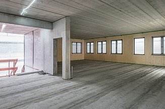Ansicht eines Raumes im Rohbau mit Betondecke und Holzaußenwänden